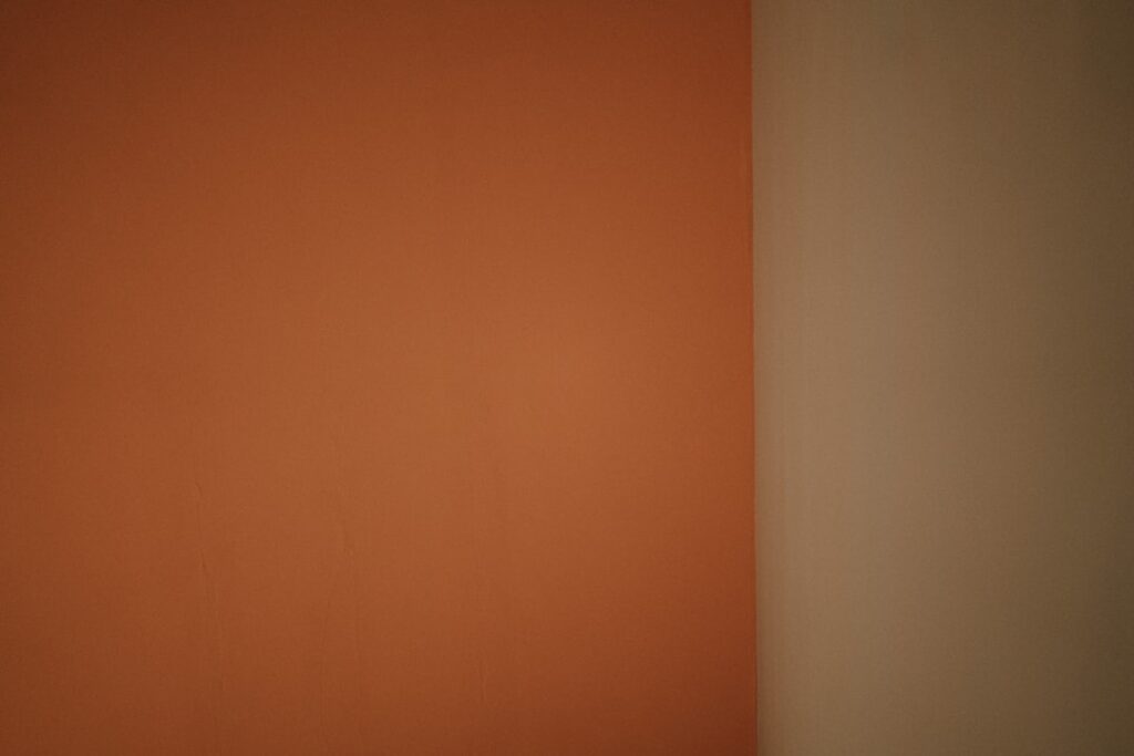 a white toilet sitting in a bathroom next to a wall